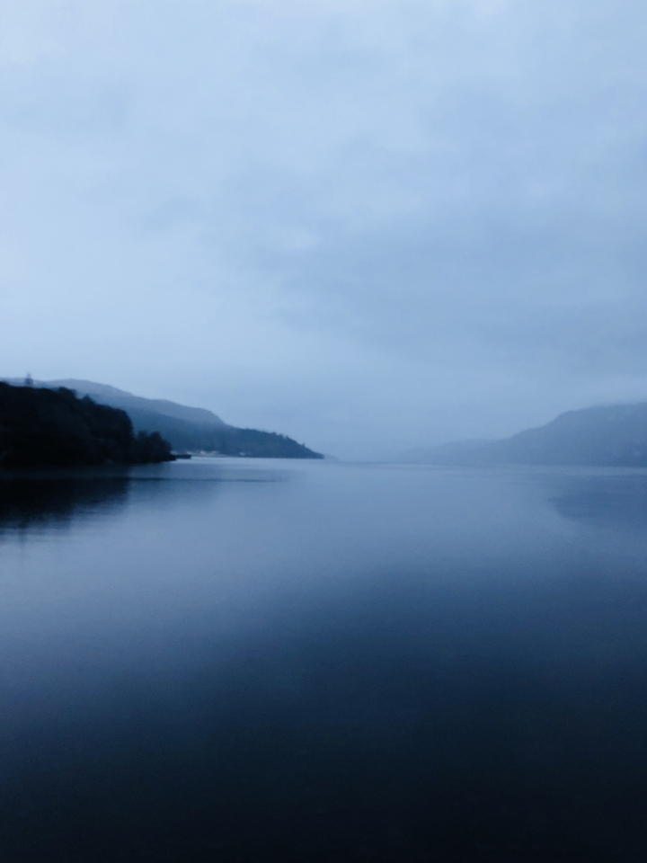 Misty lake with mountains in the distance.
