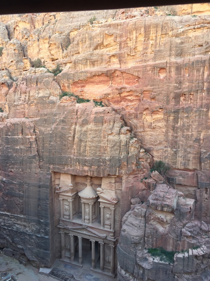 Temple with many people holding colorful umbrellas.