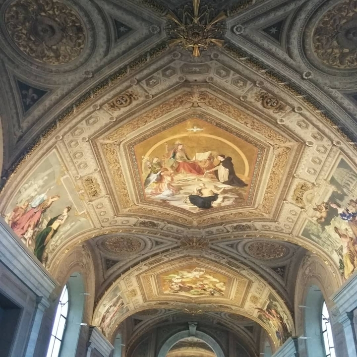 Ornate ceiling with detailed frescoes and gilding.