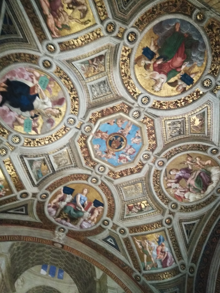 Intricate ceiling design with multiple paintings.