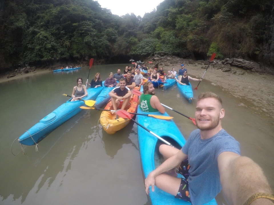 Group of people kayaking in a river surrounded by cliffs.