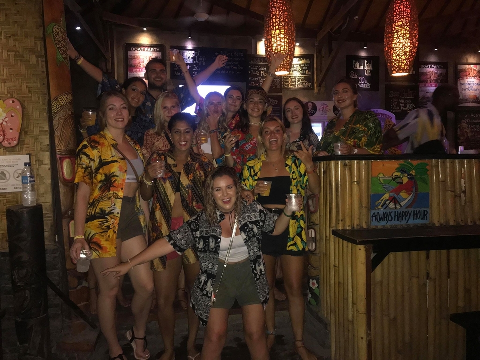 Group photo in a bar with people holding drinks.