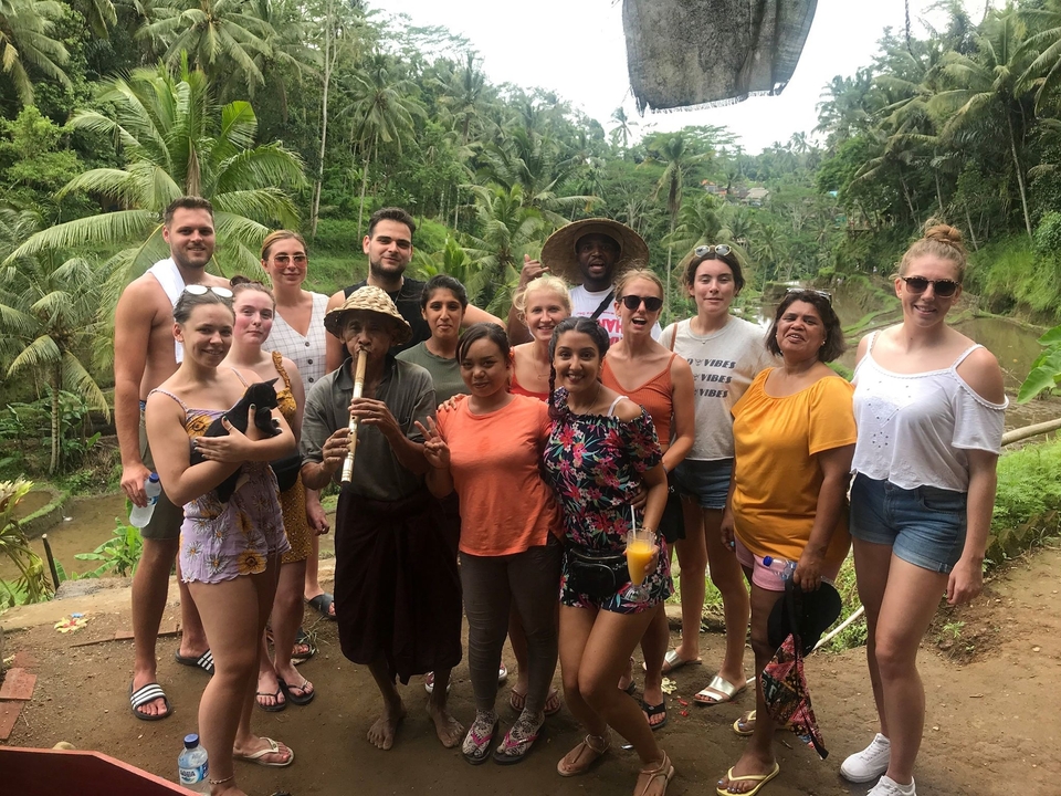 Group of people posing together in a lush setting.