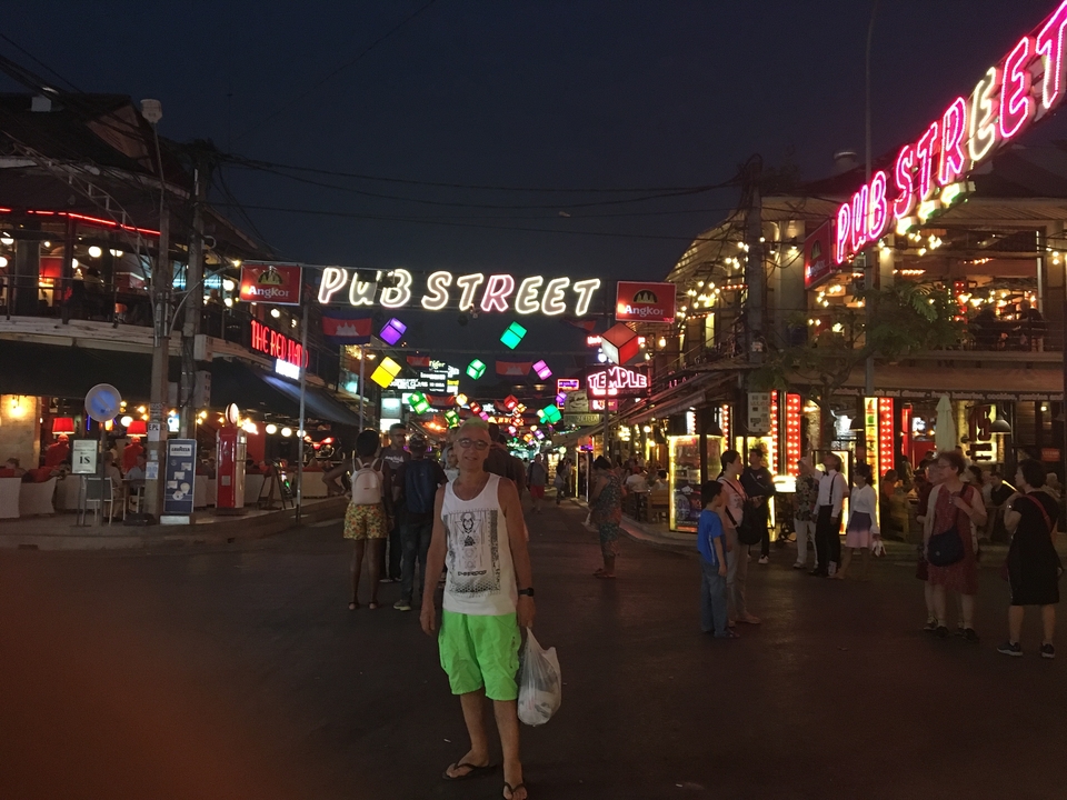 Rue animée avec des néons et des devantures de magasins.