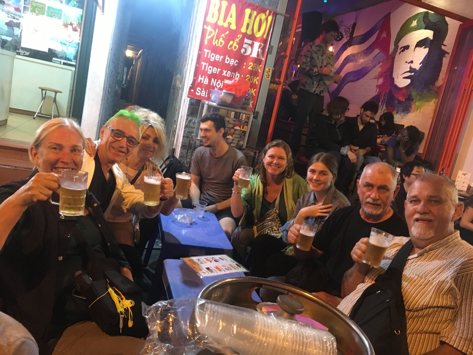 Groupe de personnes savourant des boissons au marché nocturne.