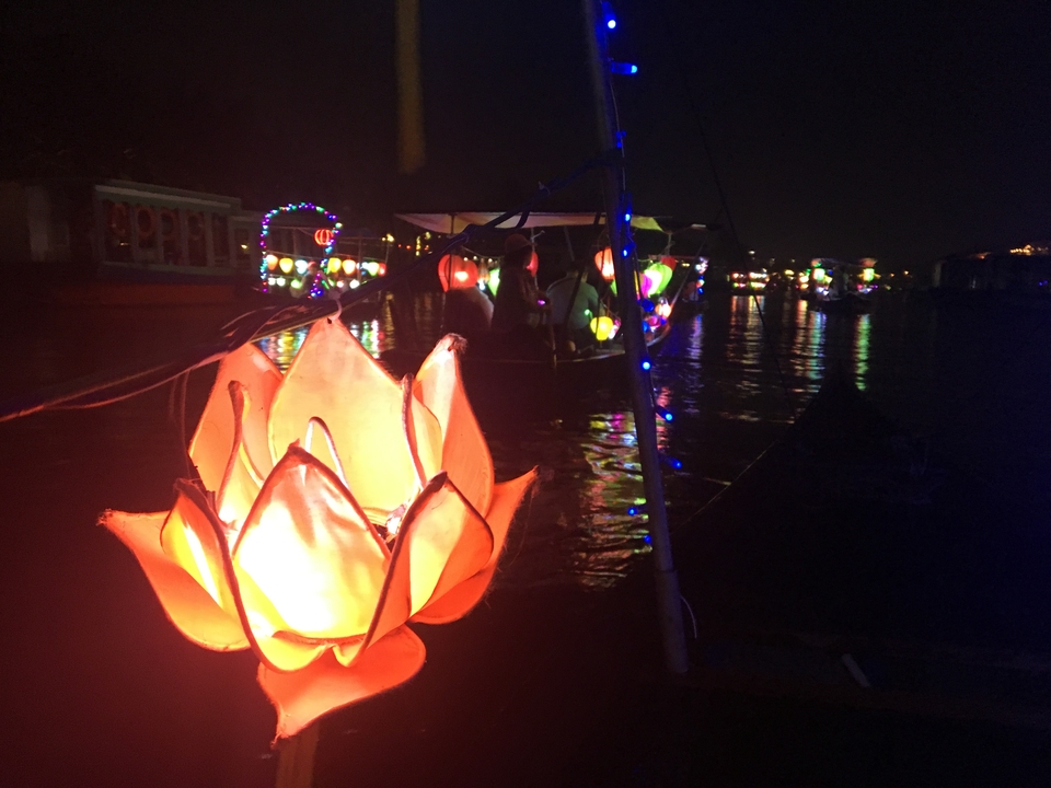 Lanternes flottant sur une rivière la nuit.