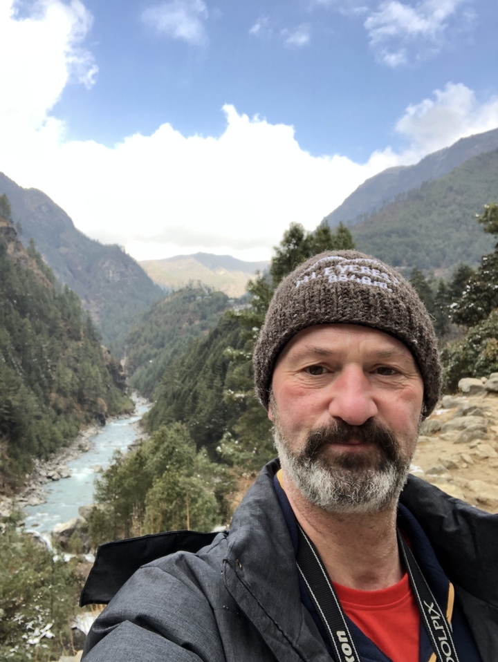 Portrait of a man in a scenic mountain landscape.