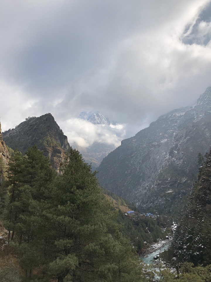 Mountain landscape with clouds and snow-capped peaks.