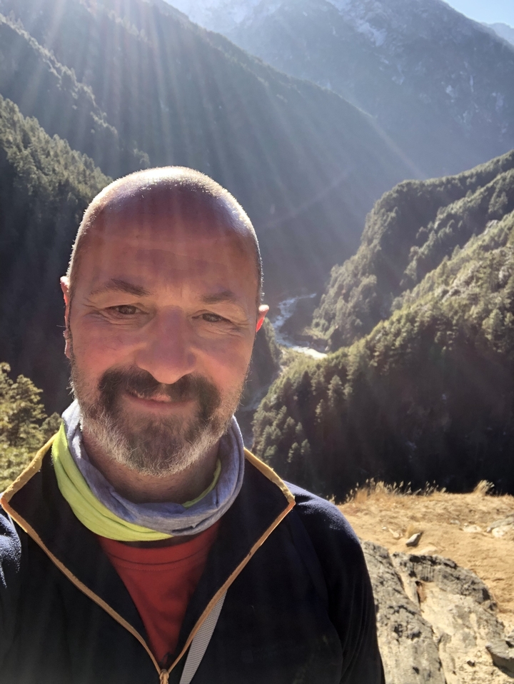 Portrait of a man in a mountain landscape with sunlight.