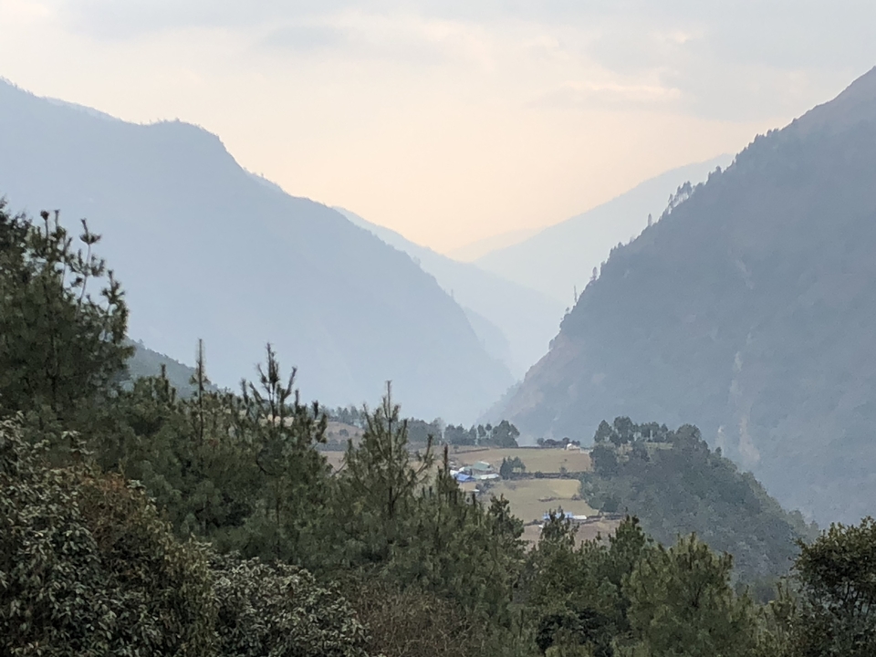 Valley view with mountains and distant fields.
