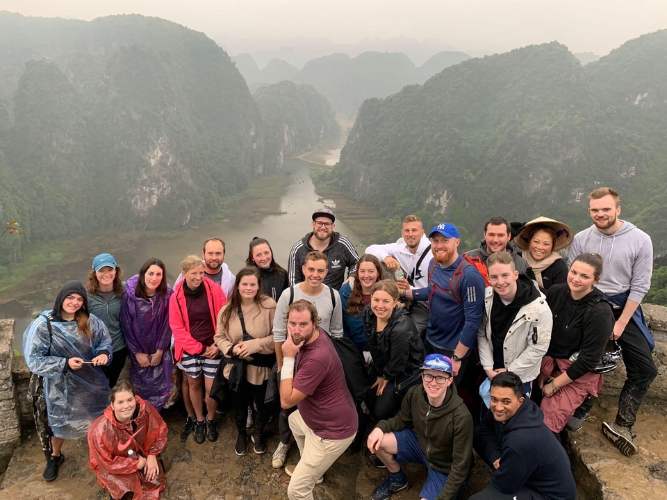 Group photo with a scenic mountainous backdrop.