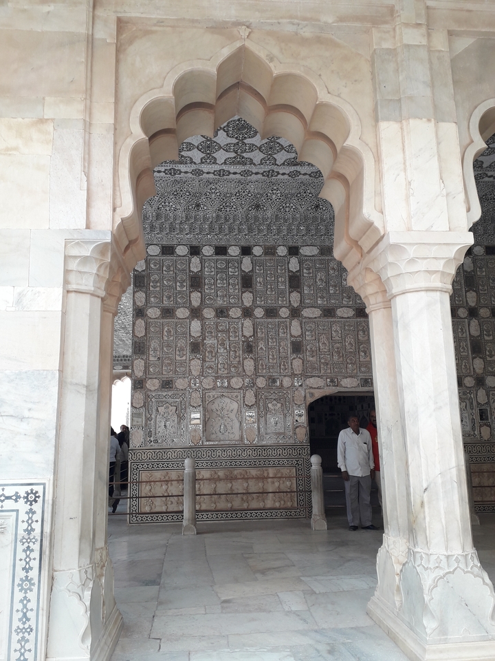 Interior de un palacio con arcos decorativos y columnas.