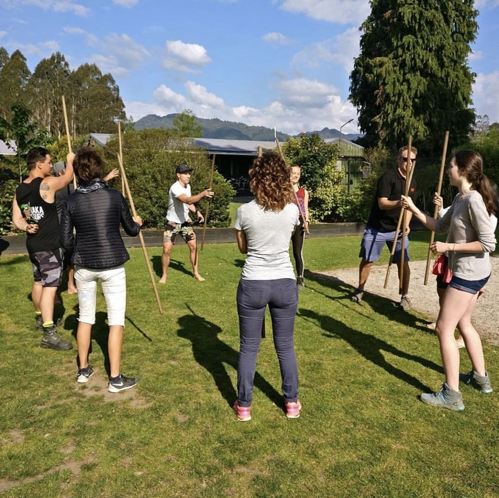 Group engaged in an outdoor stick game.