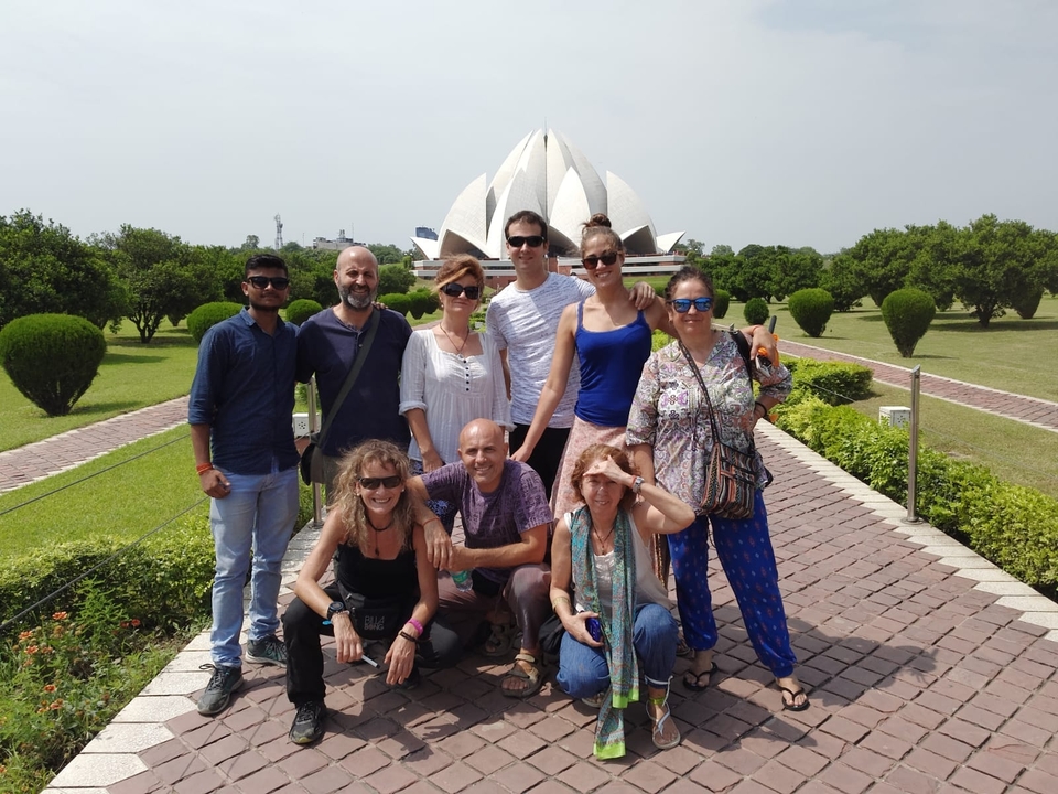 Groupe de personnes posant devant un bâtiment en forme de lotus.