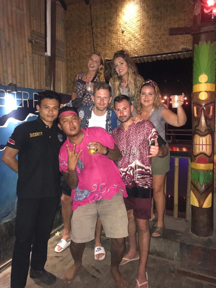 Group of people posing together in a bar or club.
