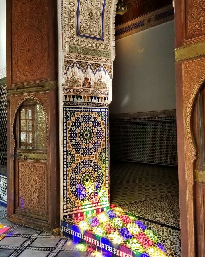 Intricate mosaic and tile work on a wall inside a building.