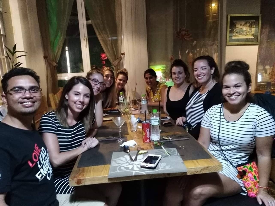 Group of people sitting around a dining table.