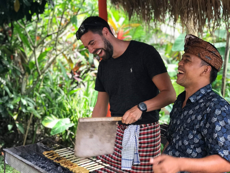 Two men laughing and cooking together.