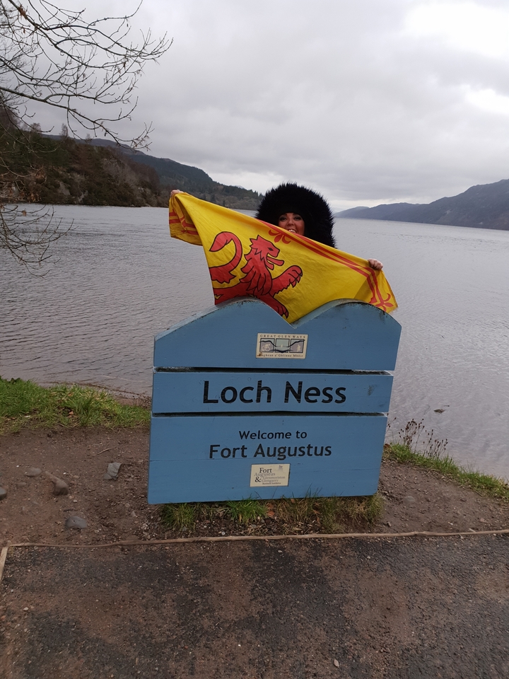 Sign and person with a flag at Loch Ness.