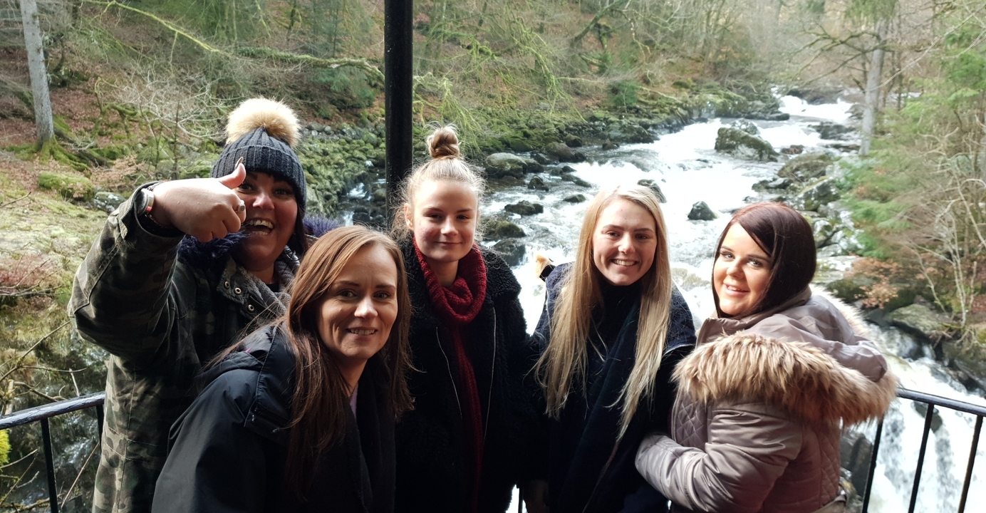 Group of people posing near a river.