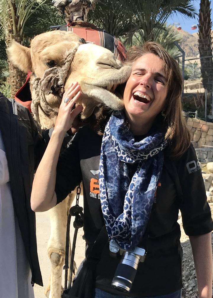 Woman interacting with a camel.