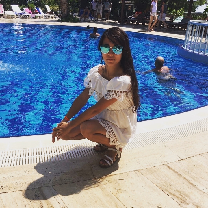 Personne près d'une piscine à l'eau bleue claire.