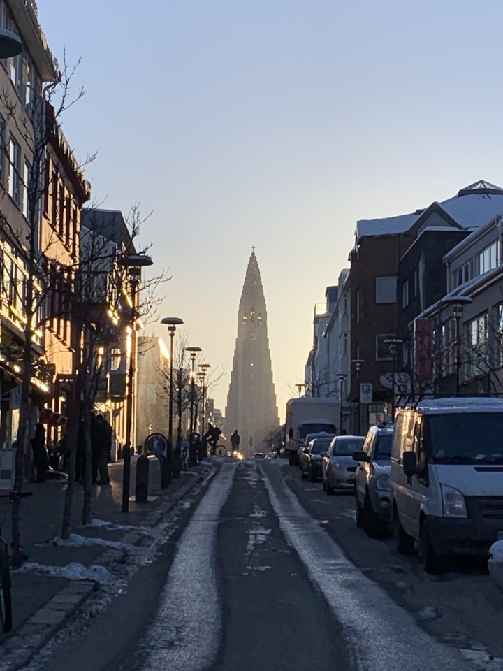 Street view with cathedral in distance and people walking by.