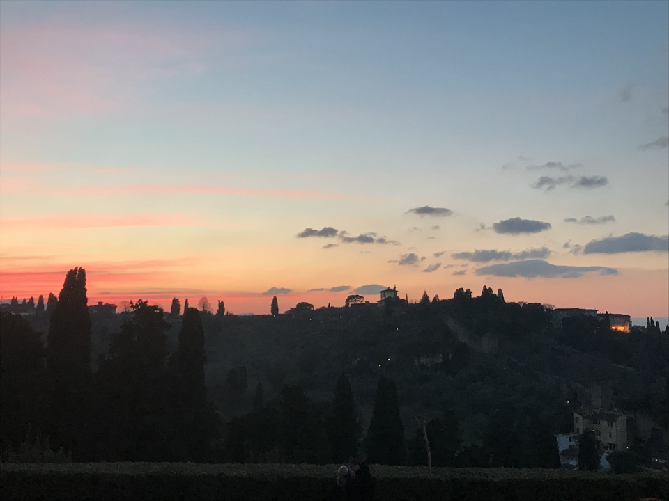 Silhouetted landscape with colorful sunset sky.