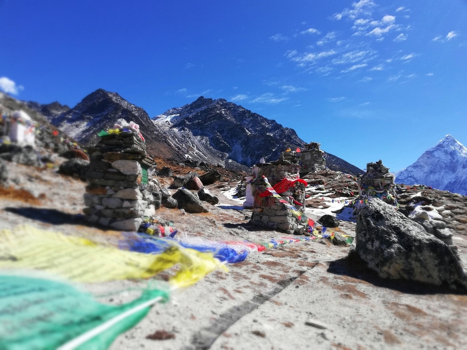 Drapeaux de prière dans l'Himalaya avec des sommets enneigés.