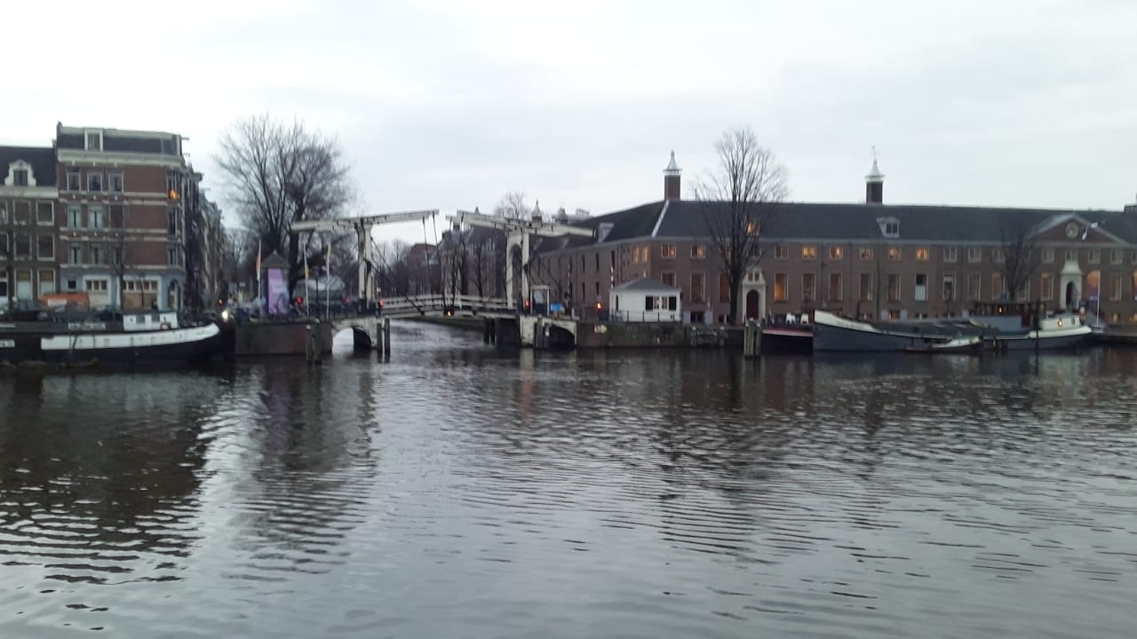 Amsterdam canal with boats and historic buildings.