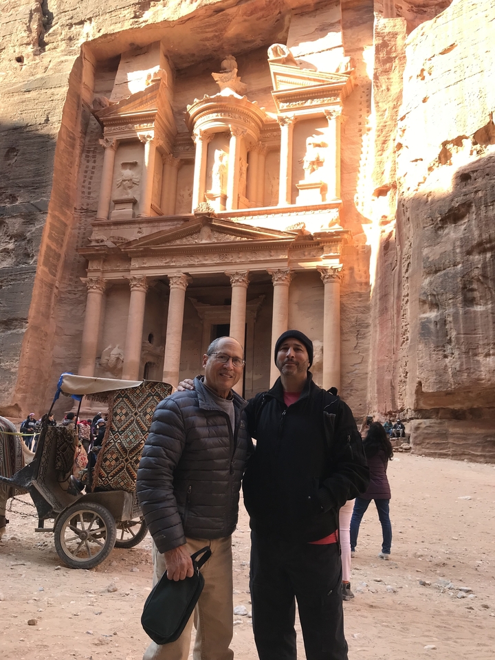 Two men posing in front of the Treasury in Petra.