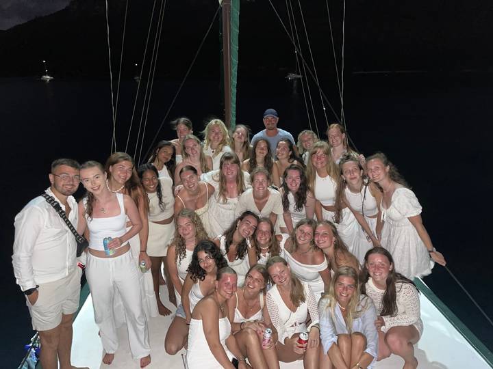 Group posing on a boat during nighttime.