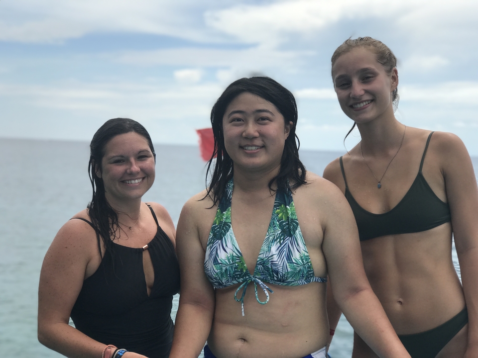 Three women in swimsuits smiling at the camera.