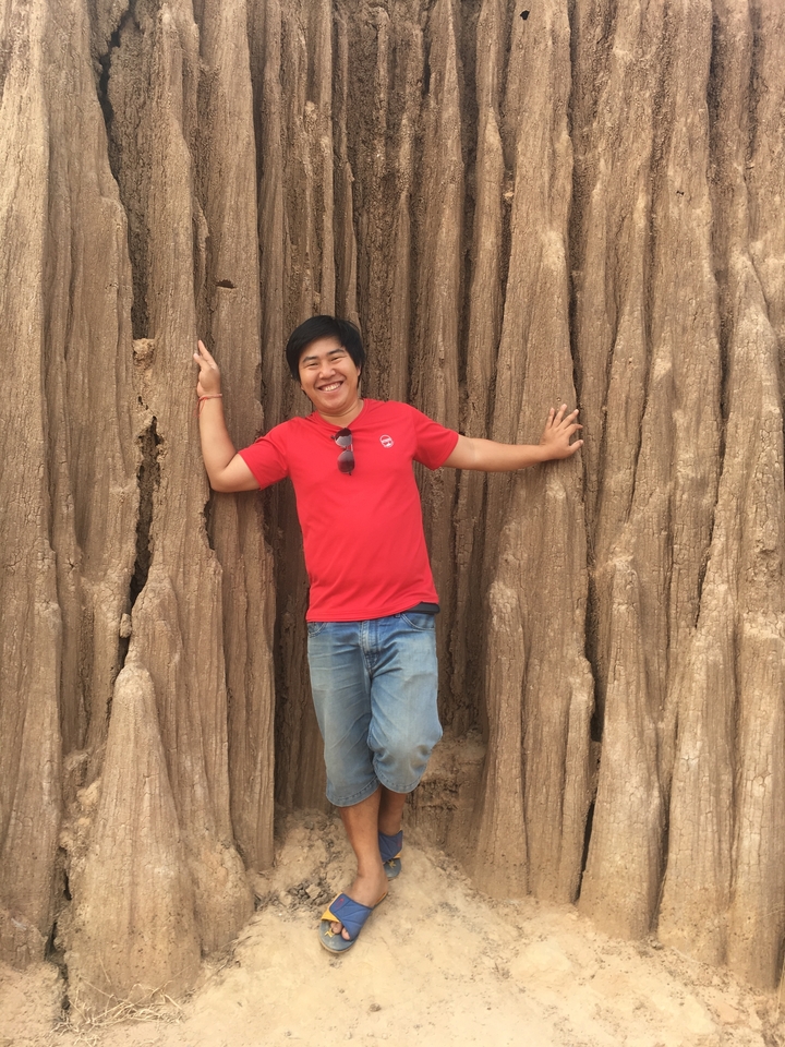 Personne posant contre un mur texturé.