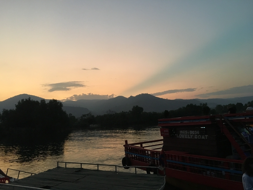 Coucher de soleil pittoresque sur un plan d'eau avec des montagnes.