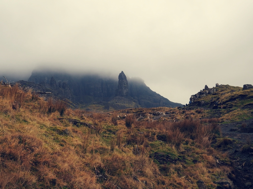 Foggy mountain landscape with sharp peaks.