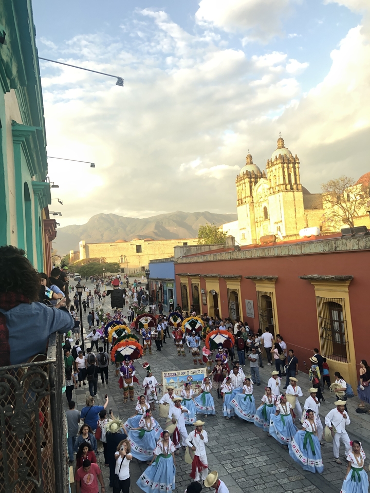 Festival de rue avec des décorations colorées et des bâtiments historiques.