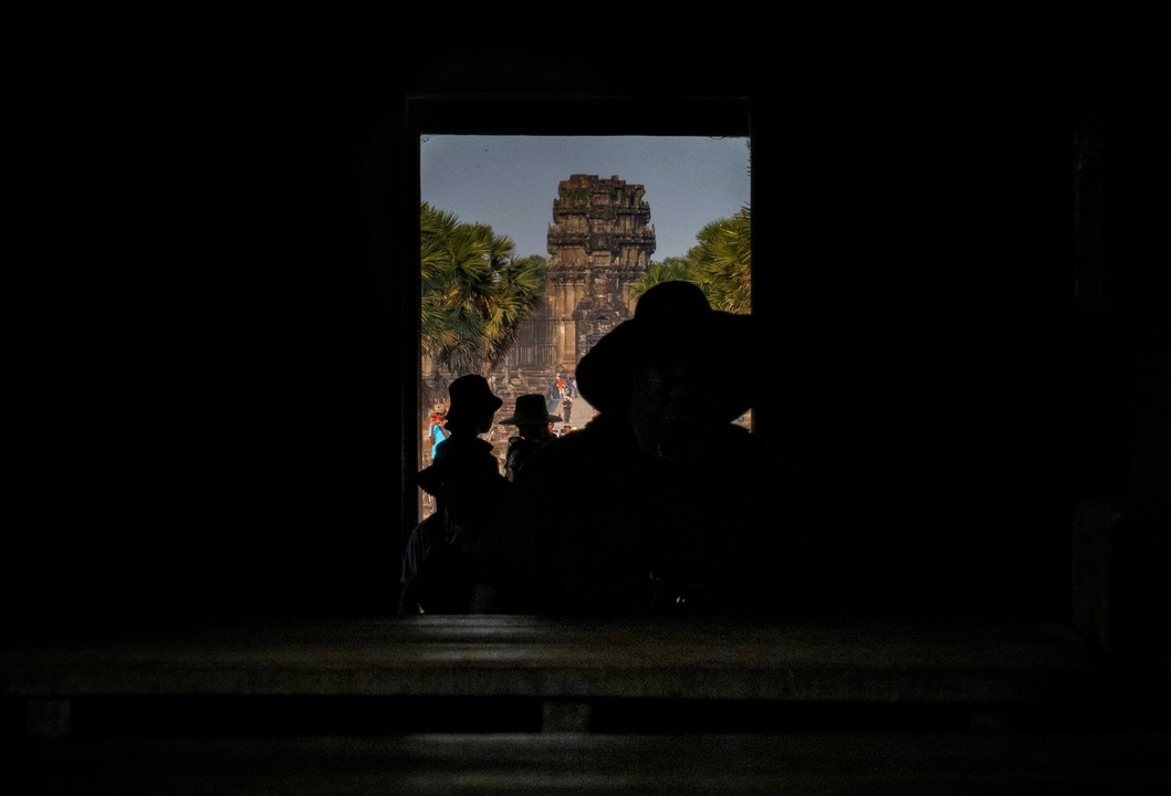 Silhouettes avec une structure de temple visible à travers une arche.