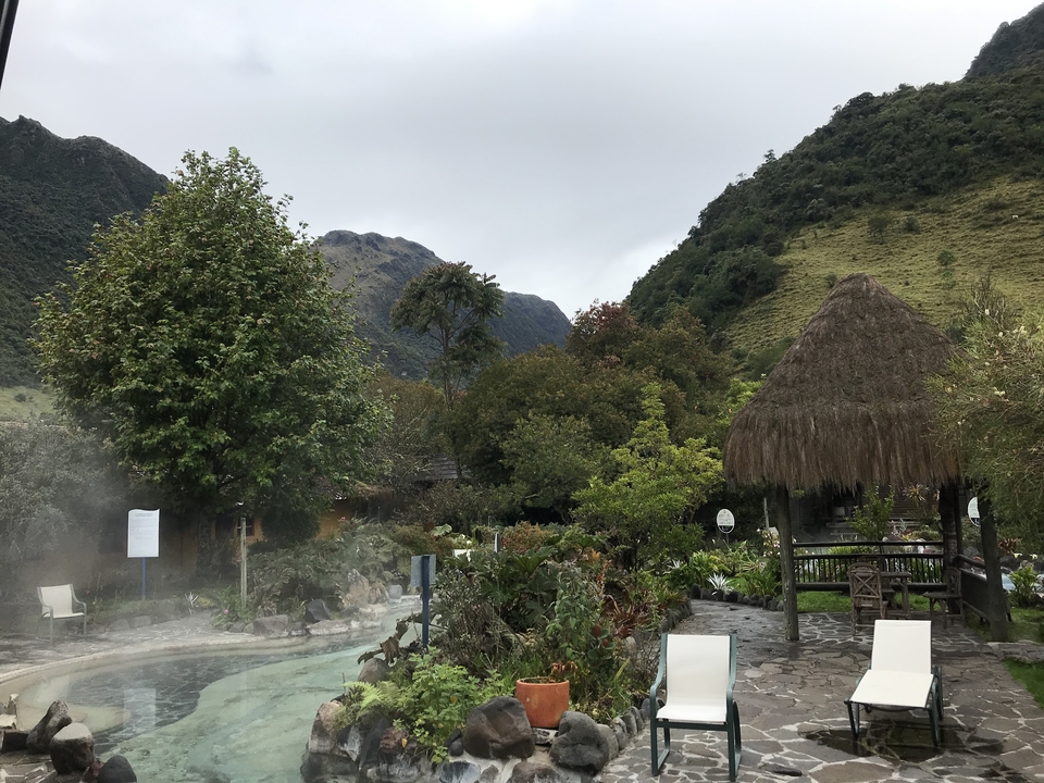 A scenic view of a hot spring resort amidst green hills.