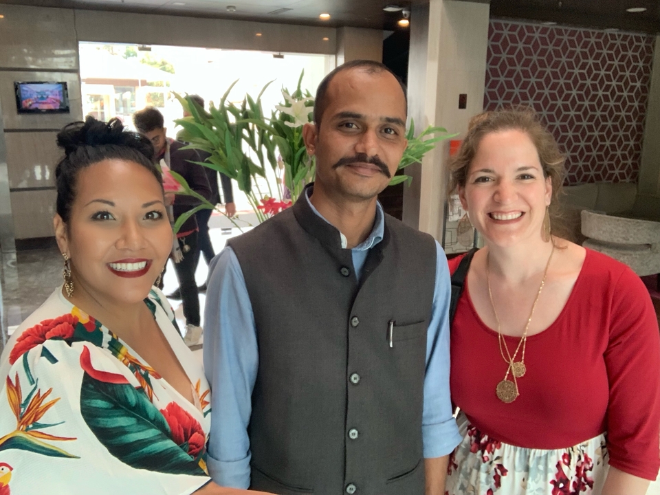 Trois personnes posant devant un décor intérieur moderne.