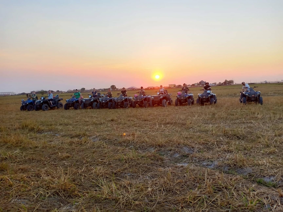 Groupe de personnes en VTT au coucher du soleil.