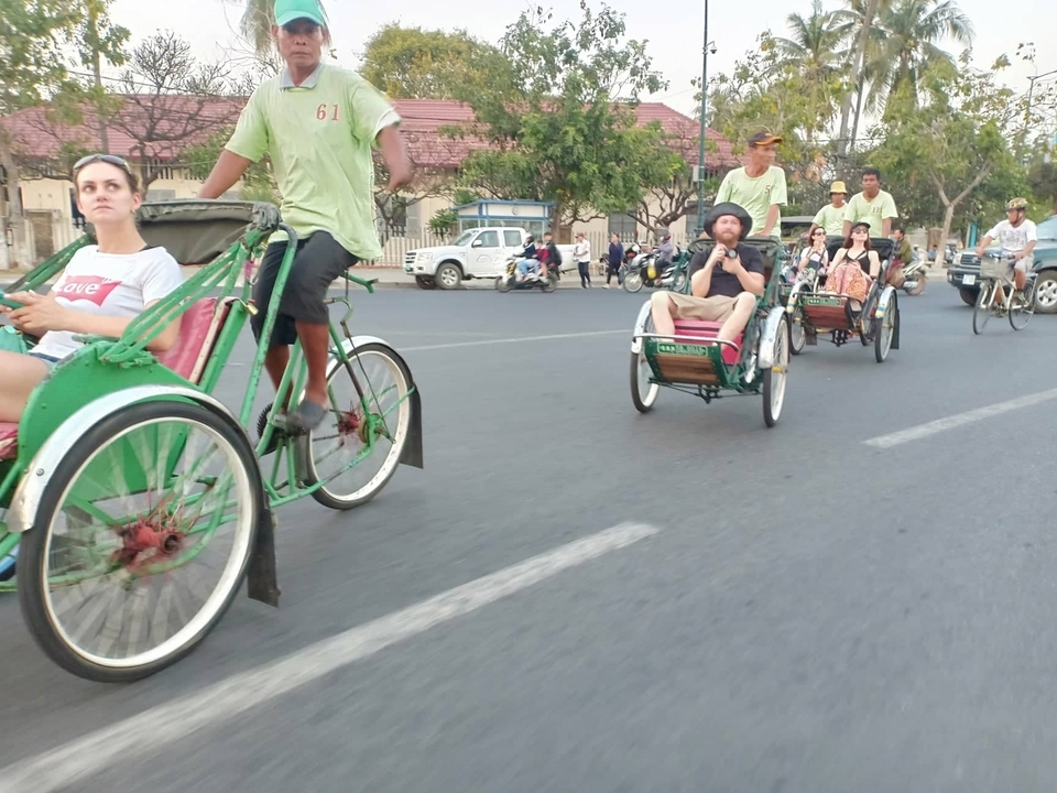 Des gens qui font du pousse-pousse à pédales dans une rue.