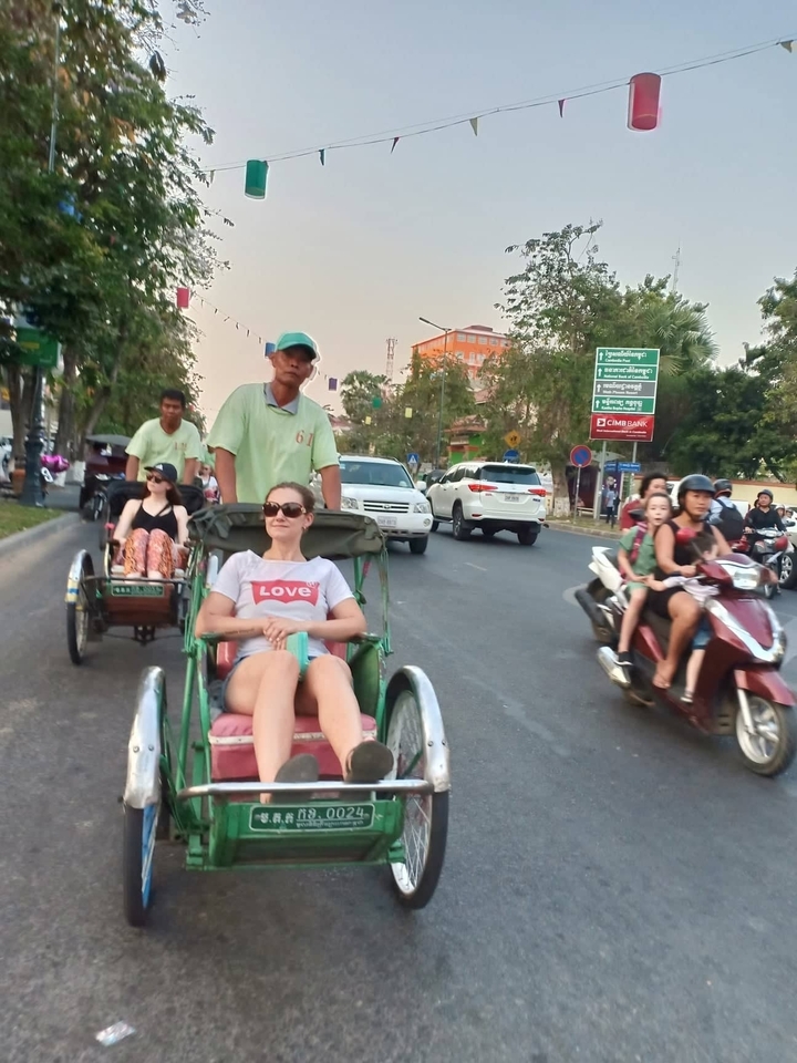 Des gens dans des pousse-pousse à pédales dans une rue animée.