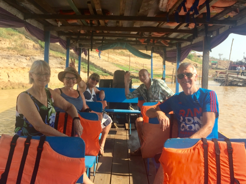 Groupe de personnes assises dans un bateau sur une rivière.
