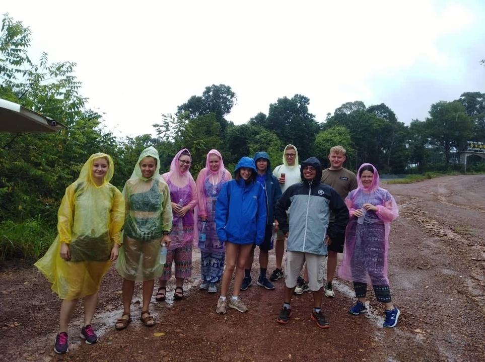 Group of people wearing rain ponchos on a rainy day.