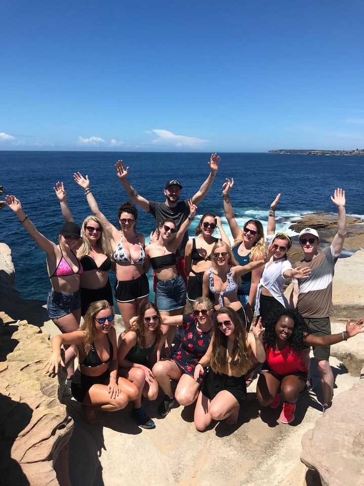 Group of people lounging on a sailboat with scenic views.