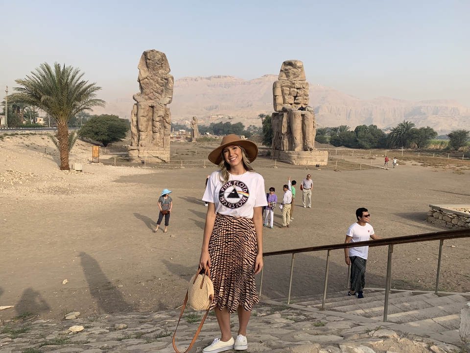 A woman posing in front of the Colossi of Memnon.