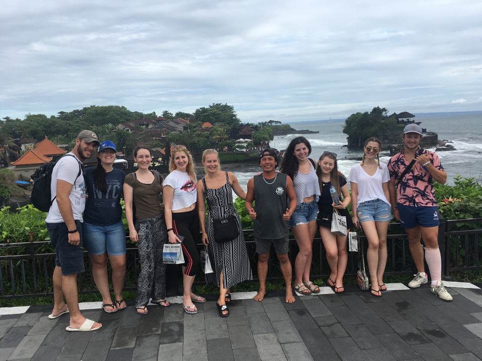 Group photo in front of a scenic coastal town.