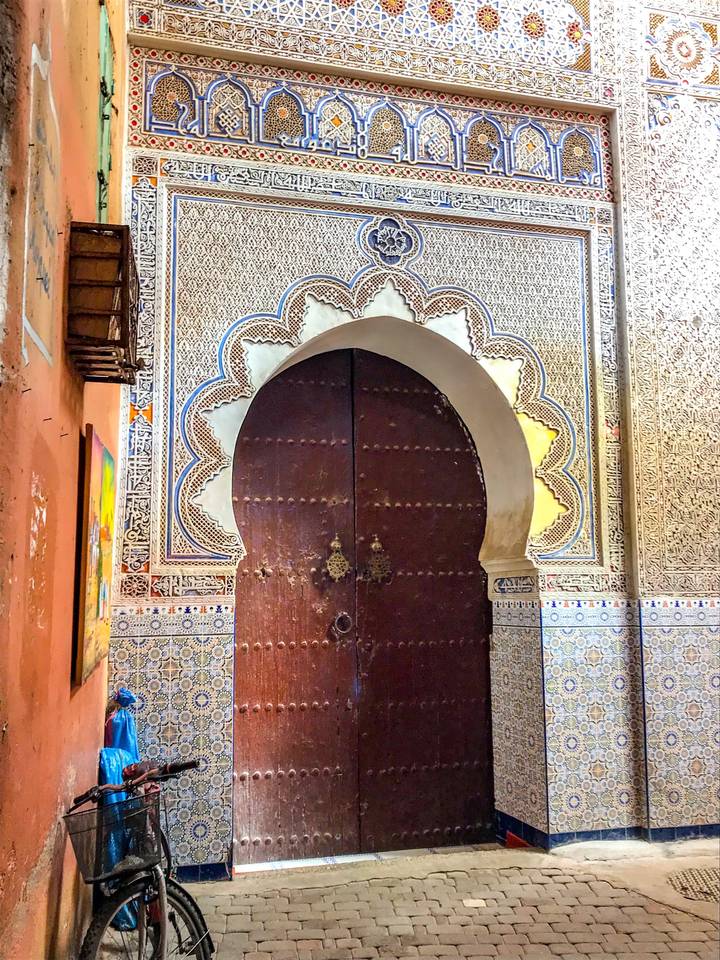 Intricately designed wooden door in a tiled wall.