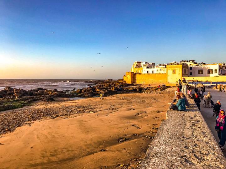 Coastal cityscape with people and seashore.